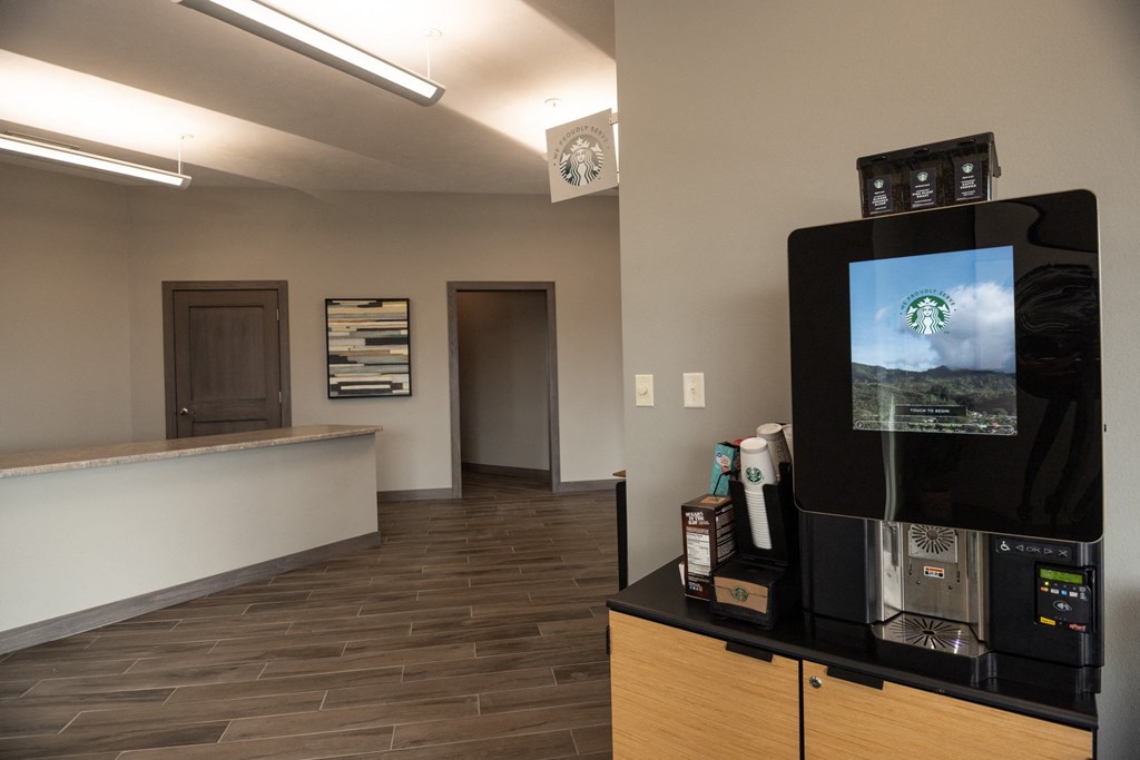 a lobby with a tv and a counter with a coffee machine