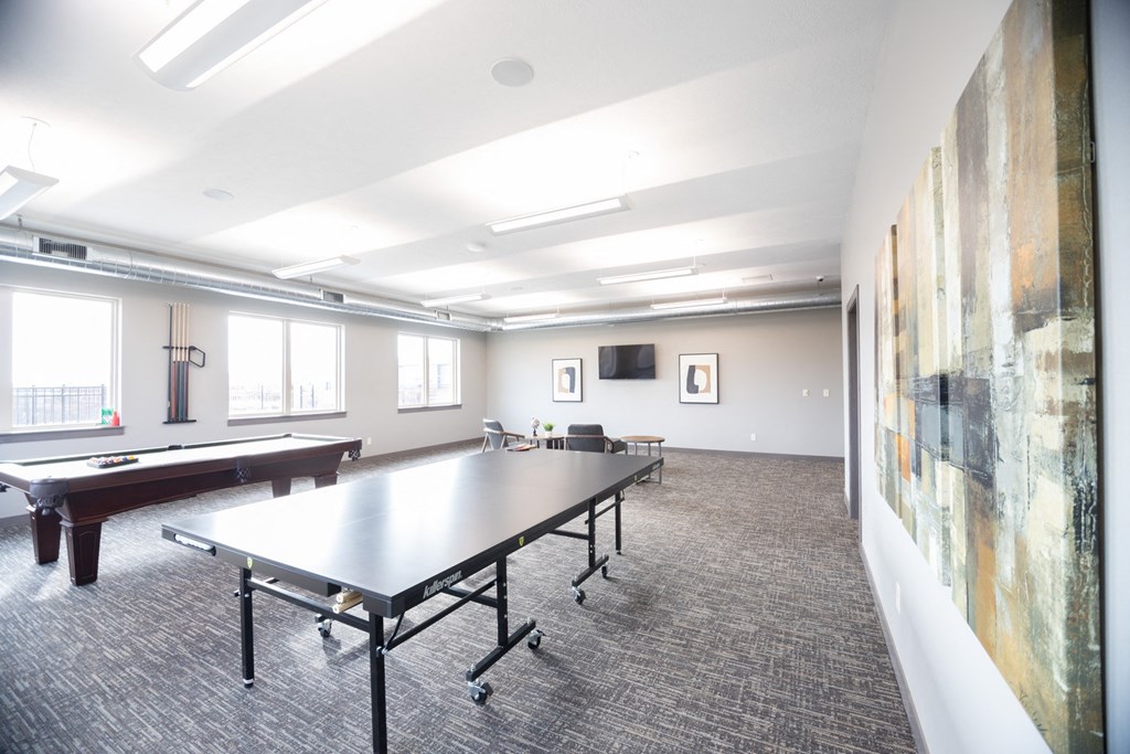 a large room with a ping pong table and a pool table
