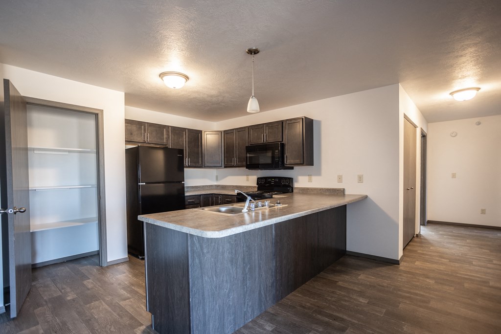 a kitchen with an island and a refrigerator and a sink