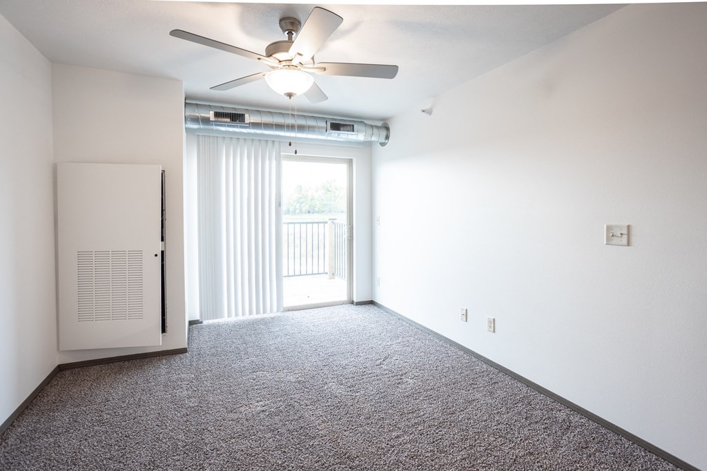 an empty living room with white walls and a ceiling fan