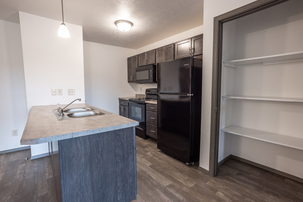 a kitchen with a stainless steel refrigerator and a sink in a renovated apartment