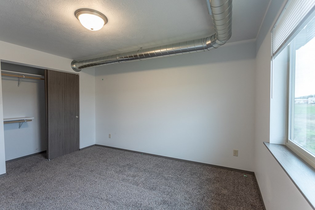 an empty room with a large window and a door