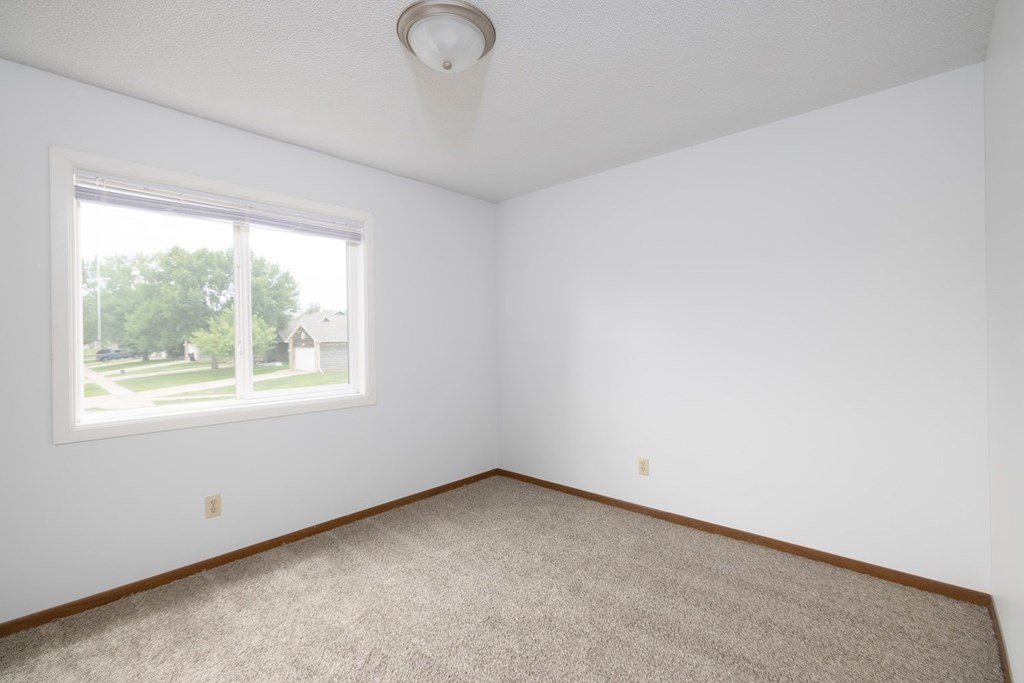 A room with a carpeted floor and a window.