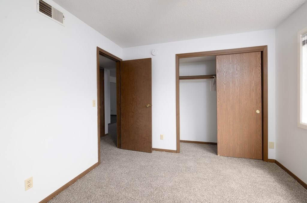 A room with two doors and a carpeted floor.