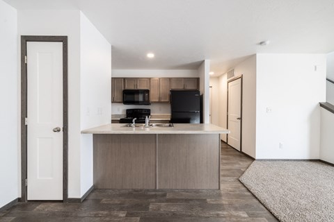 A kitchen with a black stove top oven and white cabinets.