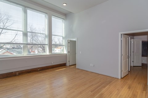 A room with a large window and wooden floors.