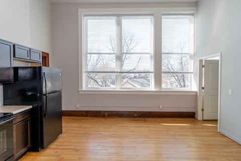 A kitchen with black appliances and wooden floors.