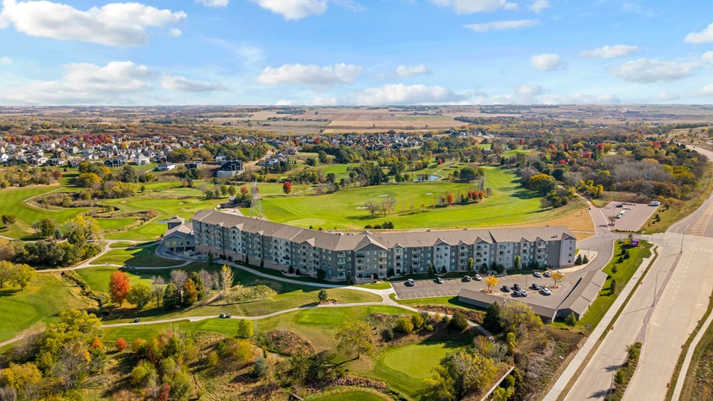 A large white building with a green lawn in front of it.