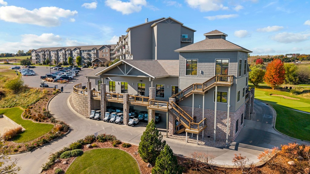 A large, modern building with a parking lot in front.
