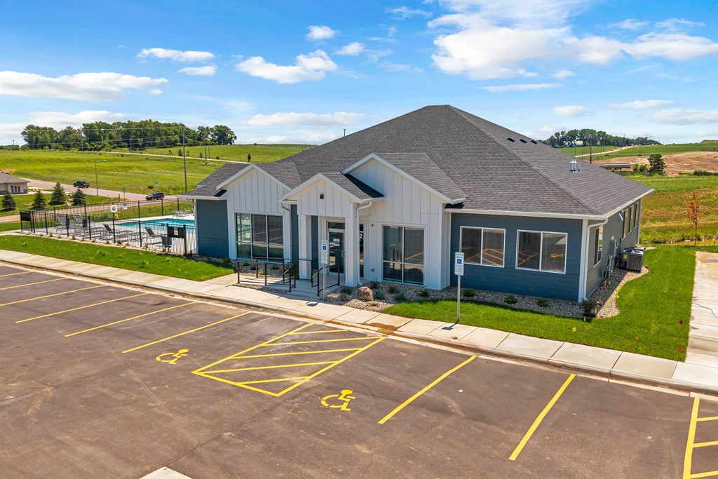 A parking lot with a building and a yellow handicap sign.