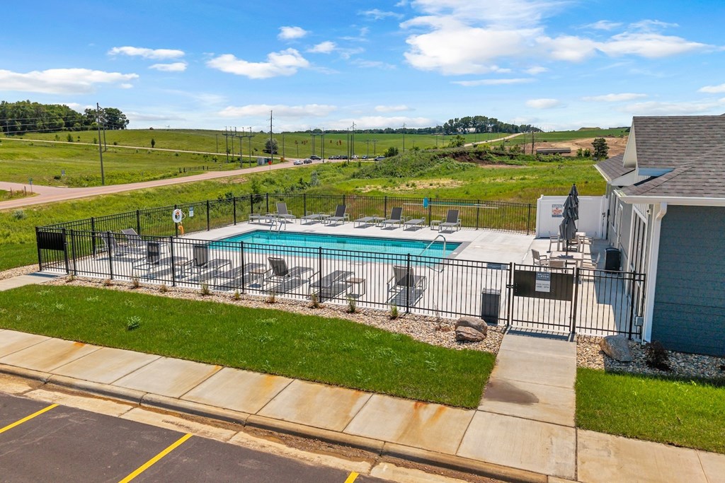 A pool surrounded by a fence and a house.