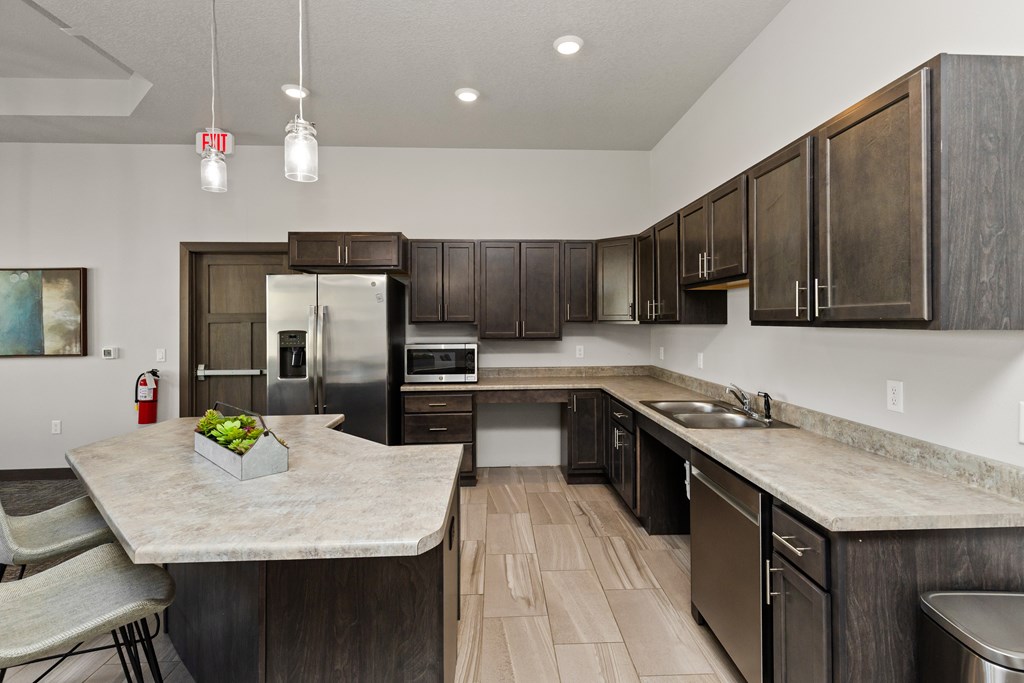 A kitchen with a marble countertop and dark wood cabinets.