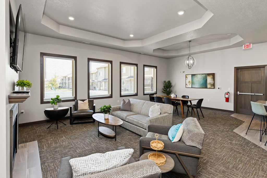 A living room with grey and white furniture and a fireplace.