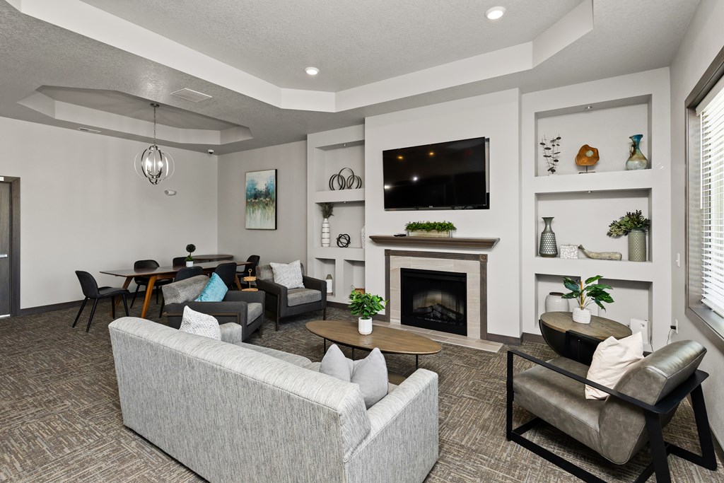 A living room with a grey couch, a fireplace, and a television.