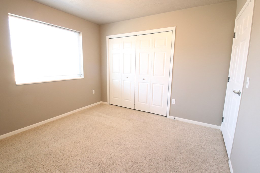 an empty room with a door and a window