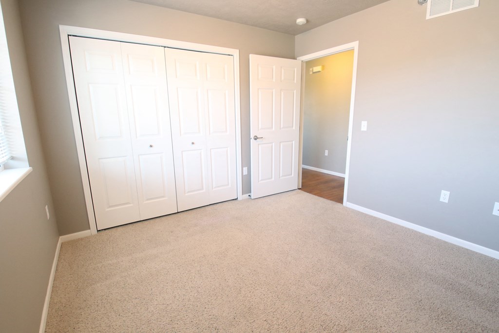an empty room with two closets and a door
