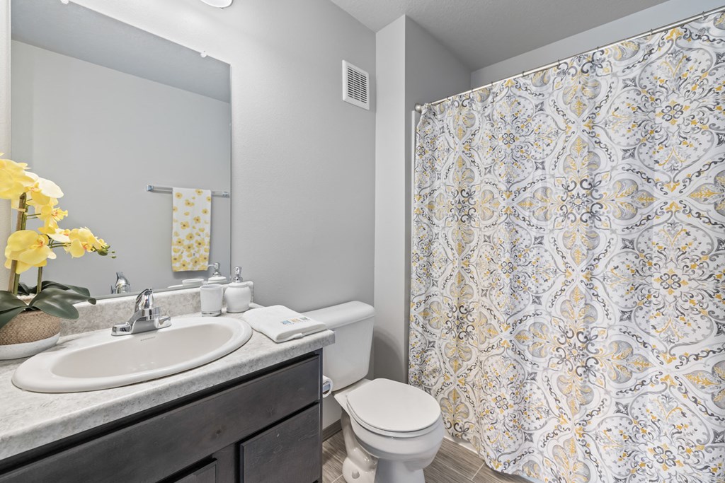 a bathroom with a shower and a toilet and a sink