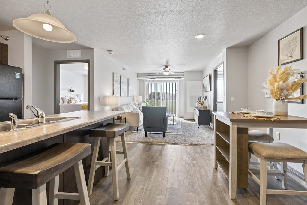 a kitchen and living room with a bar and stools