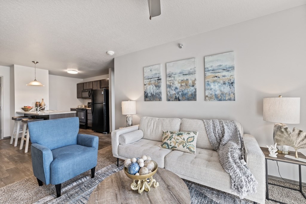 a living room with a couch and a chair and a kitchen