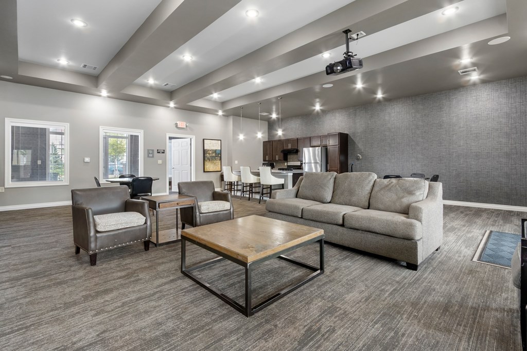 A spacious living room with a grey sofa, a wooden coffee table, and a television.
