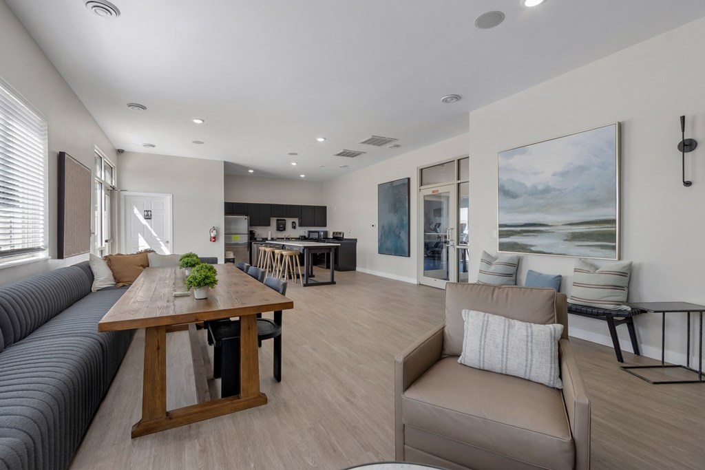A modern living room with a wooden dining table and grey sofa.