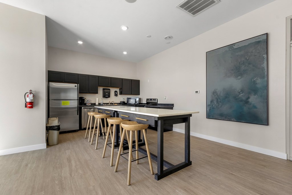 A kitchen with a table and bar stools.