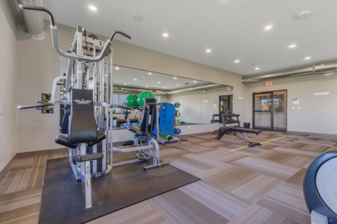 A gym with a variety of equipment including a leg press machine.