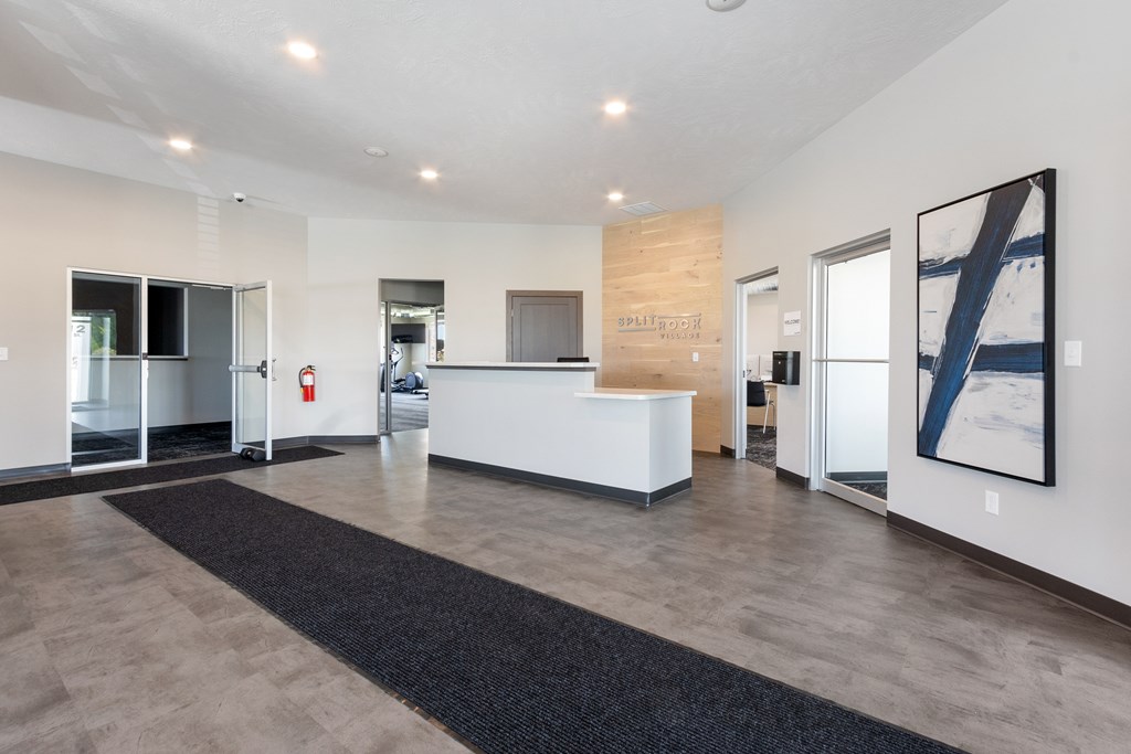 A reception area with a white reception desk and a black carpet.