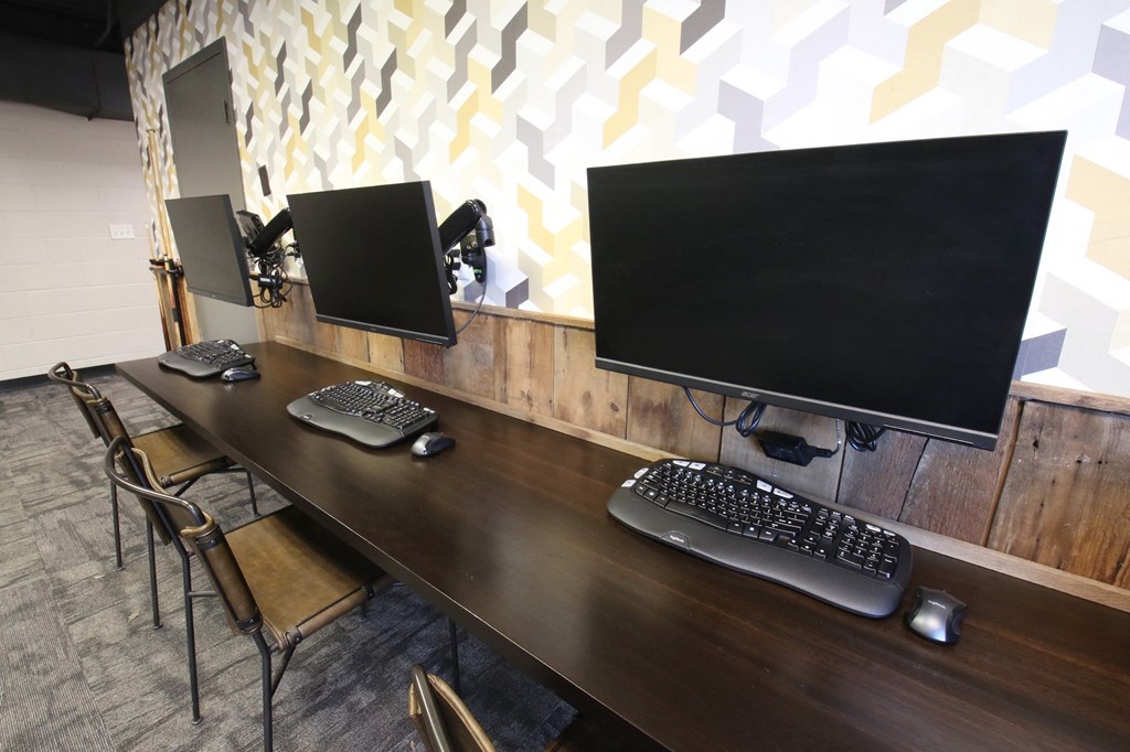 a computer desk with two monitors and keyboards on it