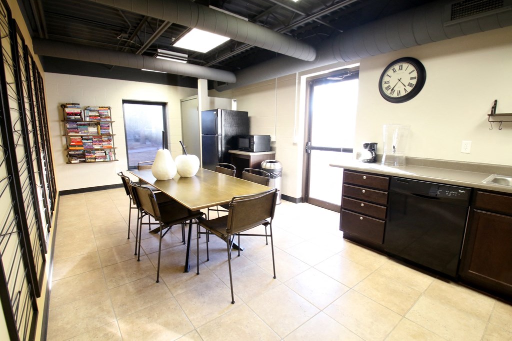 a dining room with a table and chairs and a clock on the wall
