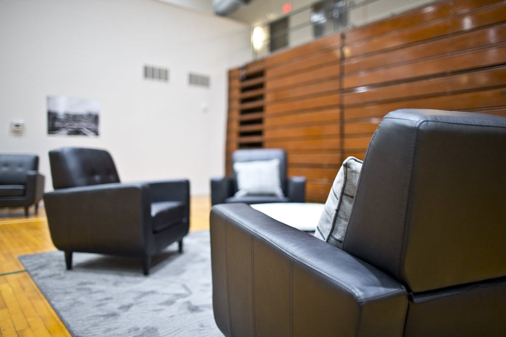 A black leather couch sits in a room with other black leather furniture.