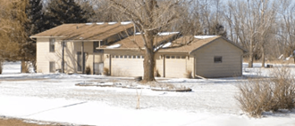 a house with a tree in front of it in the snow