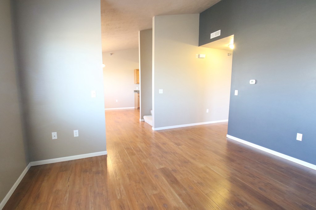 an empty living room with wood floors and blue walls