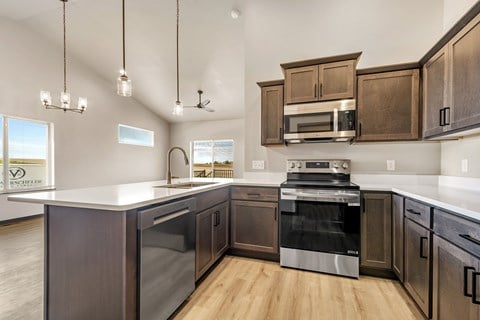 A modern kitchen with dark wood cabinets and stainless steel appliances.