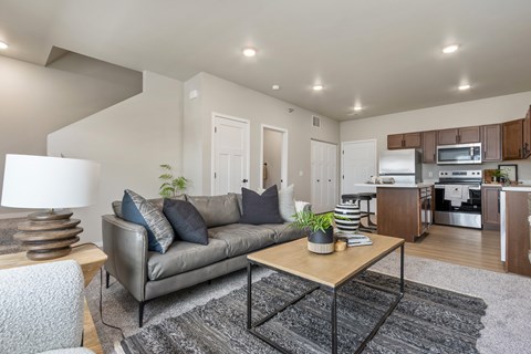 A modern living room with a grey sofa and a wooden coffee table.
