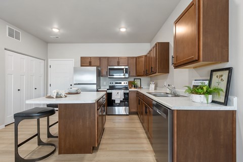 A modern kitchen with wooden cabinets and stainless steel appliances.