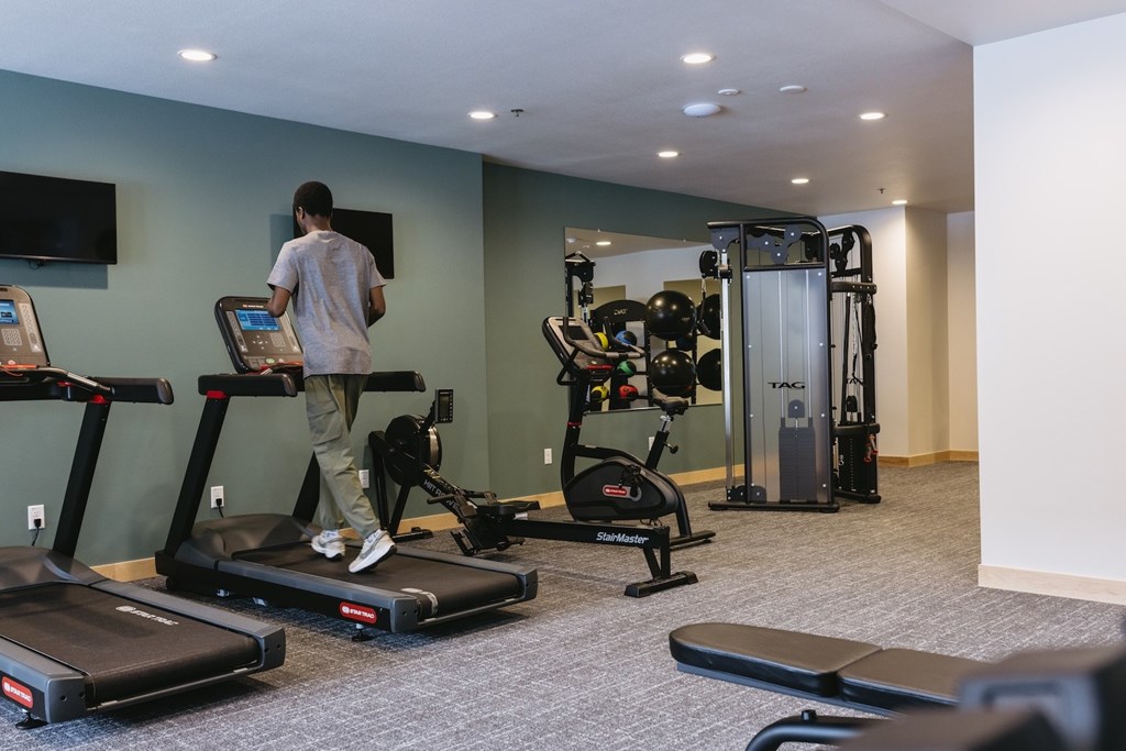 A man is using a treadmill in a gym.