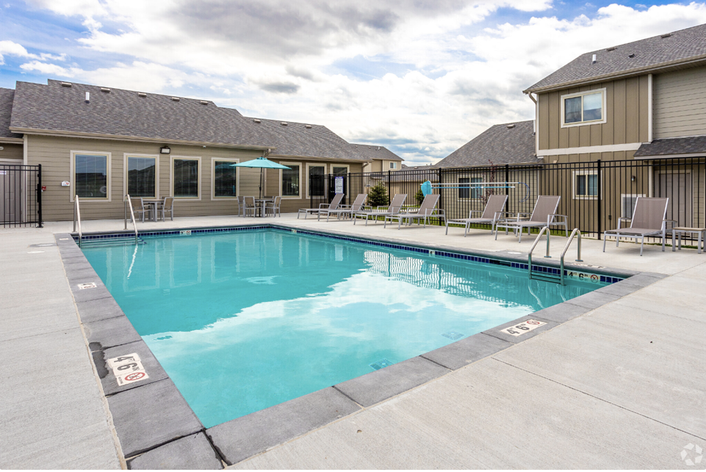 Sparkling blue pool surrounded by lounge chairs.