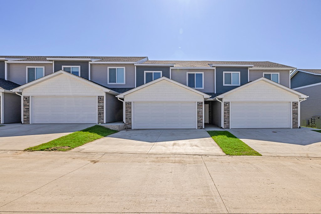 Well-maintained landscaping with manicured shrubs and paved walkways.