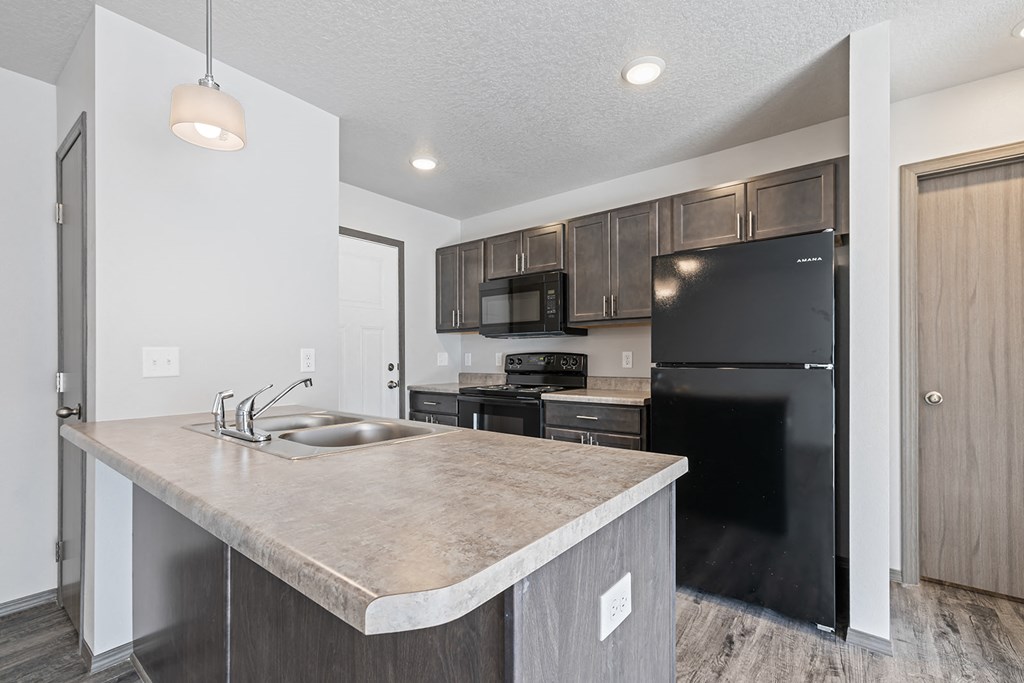 Modern open-concept kitchen and living area with black appliances.