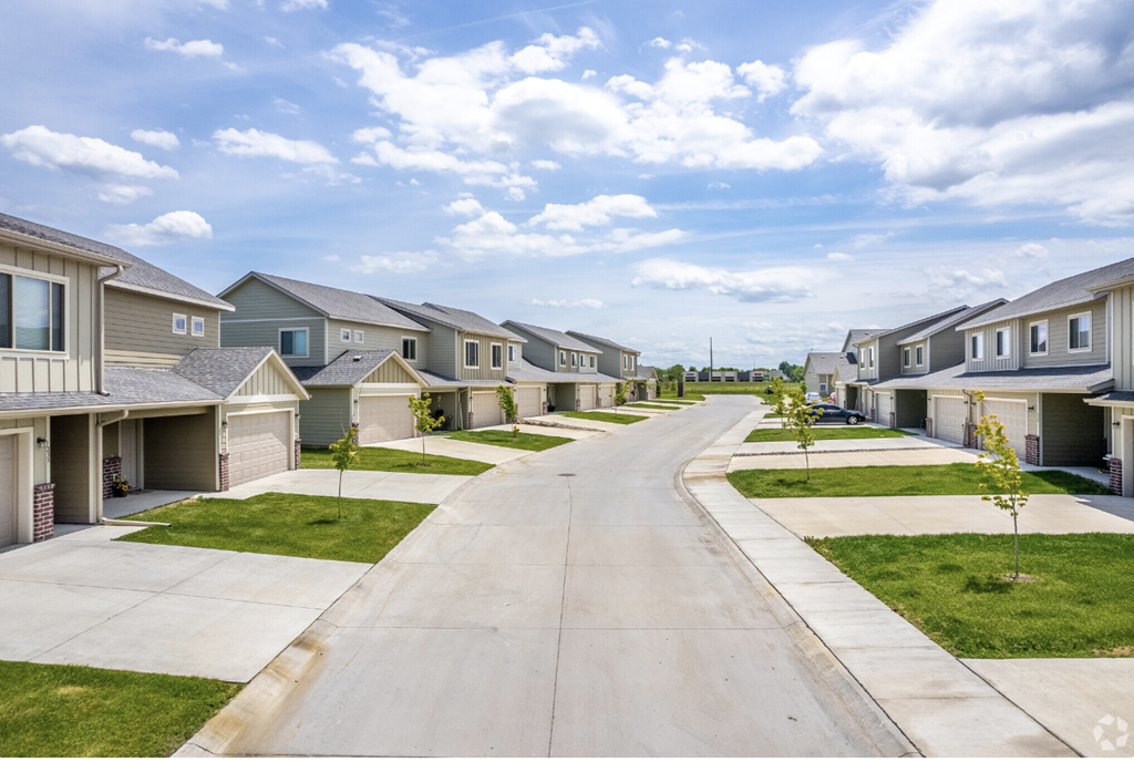 Well-maintained landscaping with manicured shrubs and paved walkways.