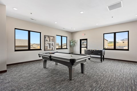A room with a pool table and a bench.