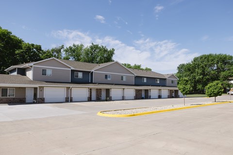 A parking lot in front of a building with a yellow line painted on the ground.