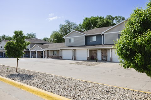 A row of houses with a gravel driveway in front.