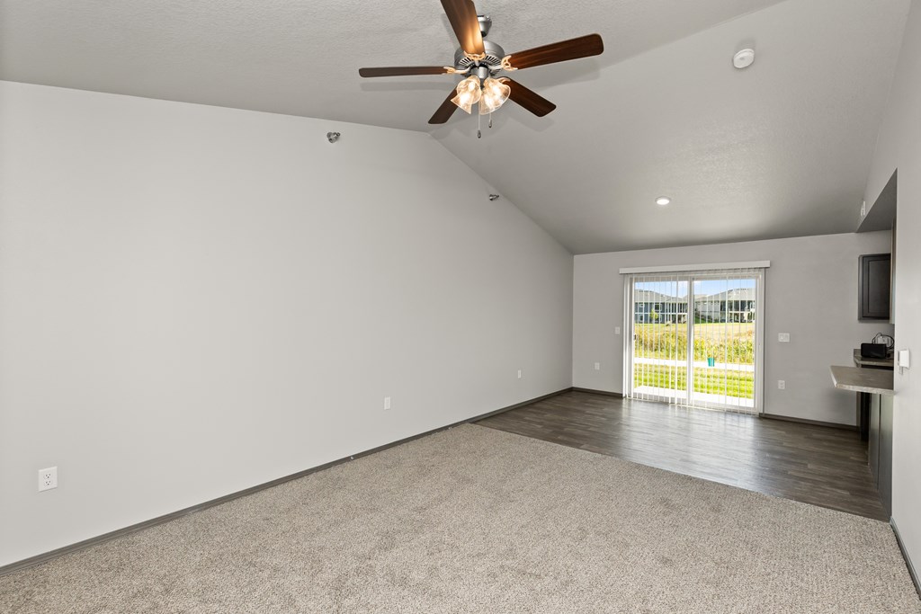 A room with a ceiling fan and a carpeted floor.
