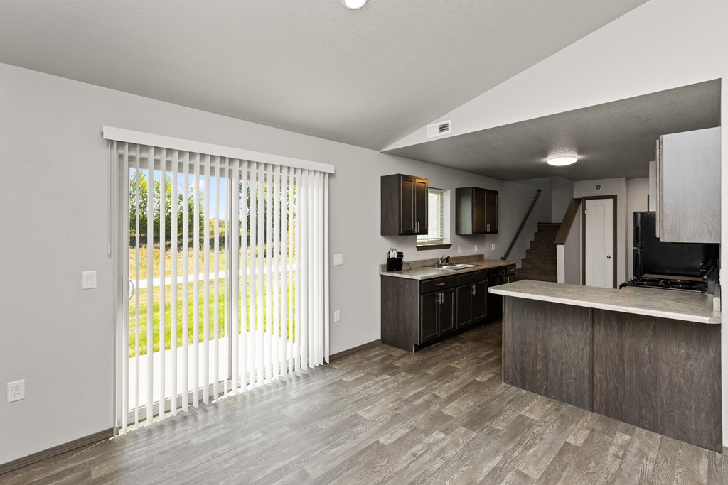 A modern kitchen with a sliding glass door leading to a backyard.