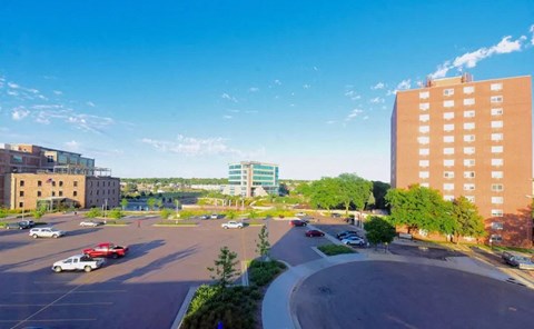 a view of a parking lot in a city with tall buildings