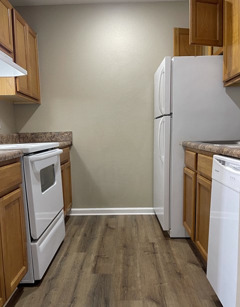 A kitchen with a white refrigerator and a white dishwasher.