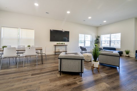 a living room with a couch and a table with chairs and a television