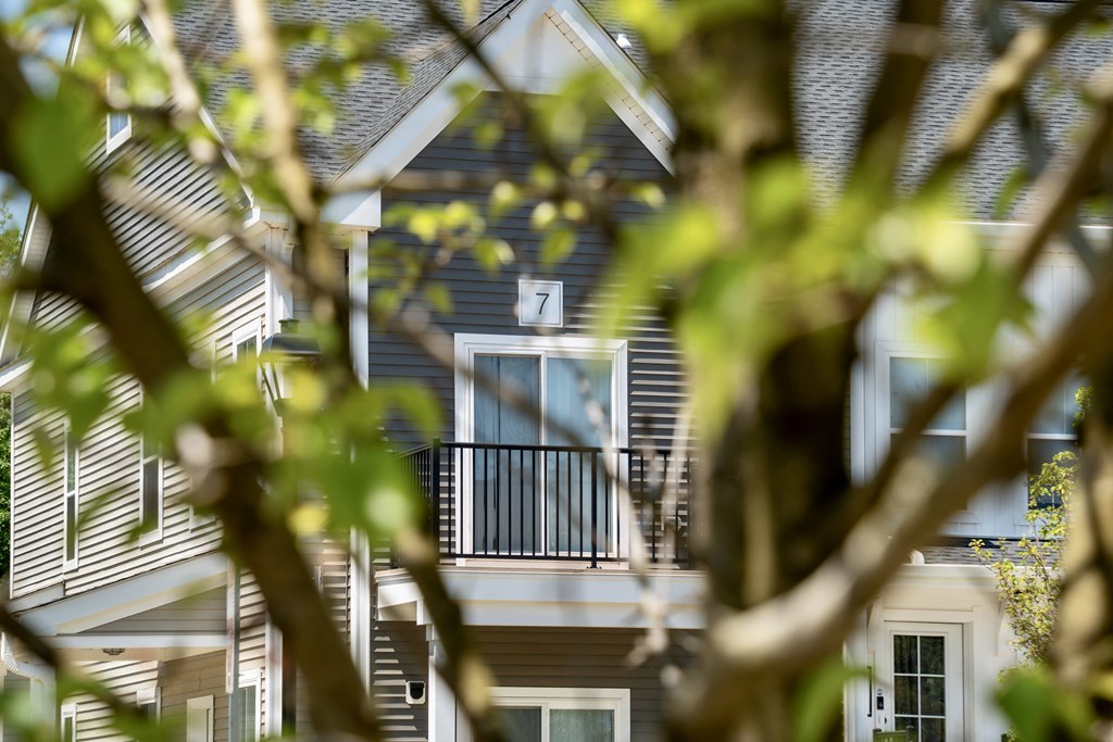 the front of a house with a balcony and a door